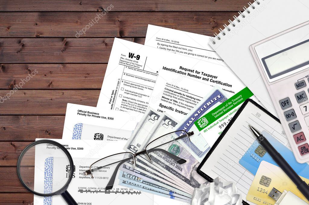 IRS form W-9 Request for taxpayer identification number and certification lies on flat lay office table and ready to fill. U.S. Internal revenue services paperwork concept. Time to pay taxes