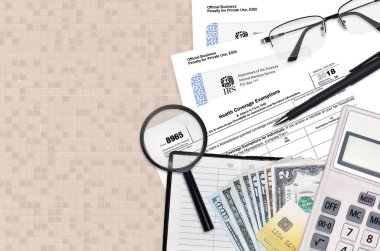 Vergi dairesi formu 8965 Sağlık Muafiyetleri düz bir ofis masasında ve doldurmaya hazır. ABD Gelir Hizmetleri evrak konsepti. Birleşik Devletler 'de vergi ödeme zamanı. Üst görünüm
