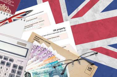 English Tax form sa105 UK Property from HM revenue and customs lies on table with office items. HMRC paperwork and tax paying process in United Kingdom of Great Britain clipart