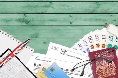 Şirket Hizmetleri 'nden kayıtlı ofis adresi değişikliğinin İngilizce formu AD01 ofis eşyalarıyla birlikte masadadır. Birleşik Krallık 'ta CH iş ve evrak süreci