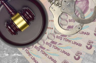 Mahkeme masasında polis kelepçeli 5 Türk lirası banknot ve yargıç çekici. Yargılama ya da rüşvet kavramı. Vergi kaçırma ya da vergi kaçırma