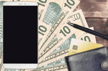 10 Amerikan doları banknotlar ve çantalı ve kredi kartlı akıllı telefon. E-ödemeler ya da e-ticaret konsepti. Taşınabilir aygıt kullanımı ile çevrimiçi alışveriş ve iş