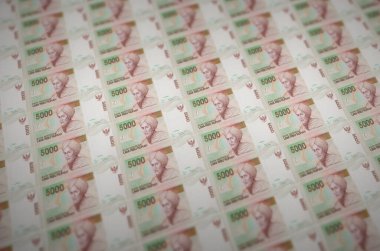 5000 Endonezya rupia senedi yasadışı para üretim taşıyıcısında basıldı. Bir sürü sahte banknot kolajı. Kalpazanlık kavramı kitlesel iş