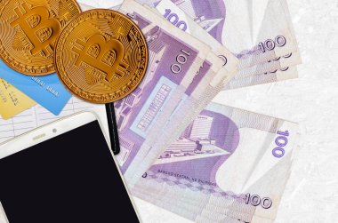 100 Filipin piso faturası ve akıllı telefon ve kredi kartlı altın bitcoin. Kripto para birimi yatırım konsepti. Kripto madenciliği veya ticari işlemler