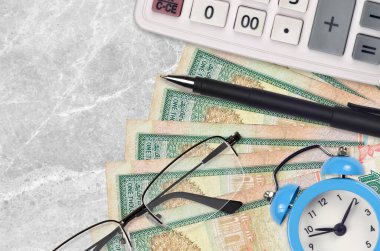1000 Sri Lanka rupisi fatura ve kalem ve gözlüklü hesap makinesi. İş kredisi ya da vergi ödeme sezonu kavramı. Mali planlama ve vergi ödeme zamanı