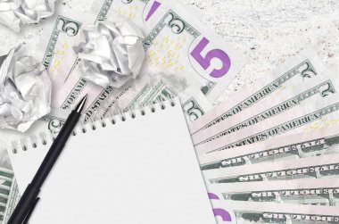 5 Amerikan doları banknotlar ve buruşmuş kağıt toplar. Kötü fikirler ya da daha az ilham konsepti. Yatırım için fikirler aranıyor