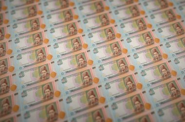 100 Ukrayna hrivniası yasa dışı para üretim taşıyıcısıyla basılmış. Bir sürü sahte banknot kolajı. Kalpazanlık kavramı kitlesel iş