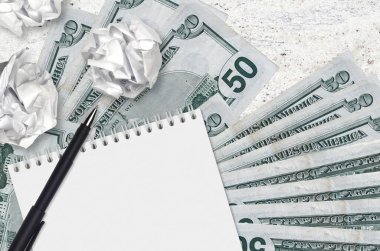 50 Amerikan doları banknotlar ve buruşmuş kağıt toplar. Kötü fikirler ya da daha az ilham konsepti. Yatırım için fikirler aranıyor