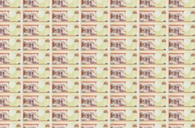 100 Dominik pezosu para üretim konveyöründe basıldı. Bir sürü banknotun kolajı. Para birimi enflasyonu ve devalüasyon kavramı