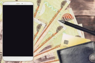 100 Dominik pezosu ve çantalı ve kredi kartlı akıllı telefon. E-ödemeler ya da e-ticaret konsepti. Taşınabilir aygıt kullanımı ile çevrimiçi alışveriş ve iş