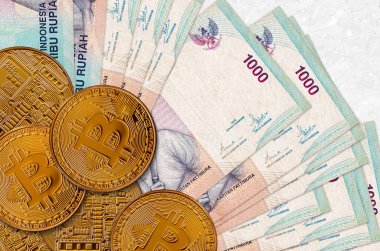 1000 Endonezya rupiası ve altın bitcoin. Kripto para birimi yatırım konsepti. Kripto madenciliği veya ticari işlemler