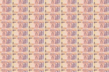 10 Hint rupi banknotları para üretim konveyöründe basıldı. Bir sürü banknotun kolajı. Para birimi enflasyonu ve devalüasyon kavramı