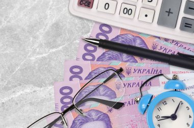 200 Ukrayna hrivniası fatura ve kalem ve gözlüklü hesap makinesi. İş kredisi ya da vergi ödeme sezonu kavramı. Mali planlama ve vergi ödeme zamanı