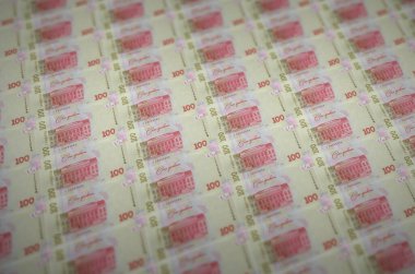 100 Ukrayna hrivniası yasa dışı para üretim taşıyıcısıyla basılmış. Bir sürü sahte banknot kolajı. Kalpazanlık kavramı kitlesel iş