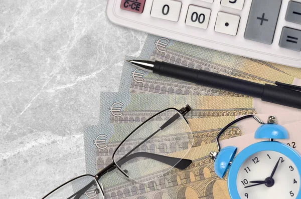 5 euro bills and calculator with glasses and pen. Business loan or tax payment season concept. Financial planning and time to pay taxes