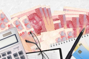 100 Tayland Baht faturası, gözlüklü ve kalemli hesap makinesi. Vergi ödeme sezonu kavramı veya yatırım çözümleri. Mali planlama ya da muhasebeci evrakları