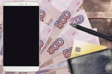 500 Rus rublesi ve çantalı ve kredi kartlı akıllı telefon. E-ödemeler ya da e-ticaret konsepti. Taşınabilir aygıt kullanımı ile çevrimiçi alışveriş ve iş