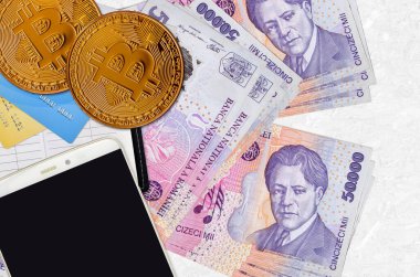 50 bin Rumen Ley faturası ve akıllı telefon ve kredi kartlı altın bitcoin. Kripto para birimi yatırım konsepti. Kripto madenciliği veya ticari işlemler