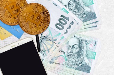 100 Çek korosu faturası ve akıllı telefon ve kredi kartlı altın bitcoin. Kripto para birimi yatırım konsepti. Kripto madenciliği veya ticari işlemler