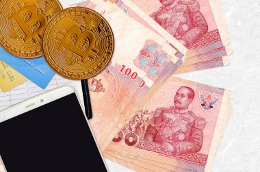 100 Tayland Baht faturası ve akıllı telefon ve kredi kartlarıyla altın bitcoin. Kripto para birimi yatırım konsepti. Kripto madenciliği veya ticari işlemler
