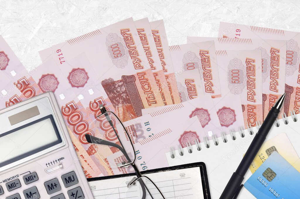 5000 russian rubles bills and calculator with glasses and pen. Tax payment season concept or investment solutions. Financial planning or accountant paperwork