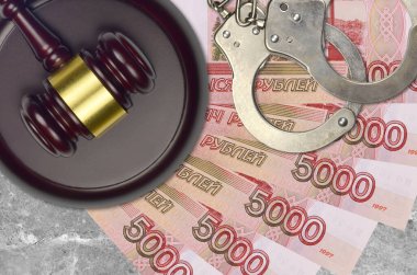 5000 Rus rublesi ve mahkeme masasında polis kelepçeli yargıç çekici. Yargılama ya da rüşvet kavramı. Vergi kaçırma ya da vergi kaçırma