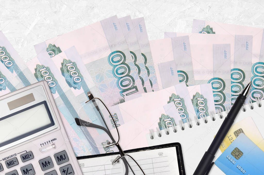 1000 russian rubles bills and calculator with glasses and pen. Tax payment season concept or investment solutions. Financial planning or accountant paperwork