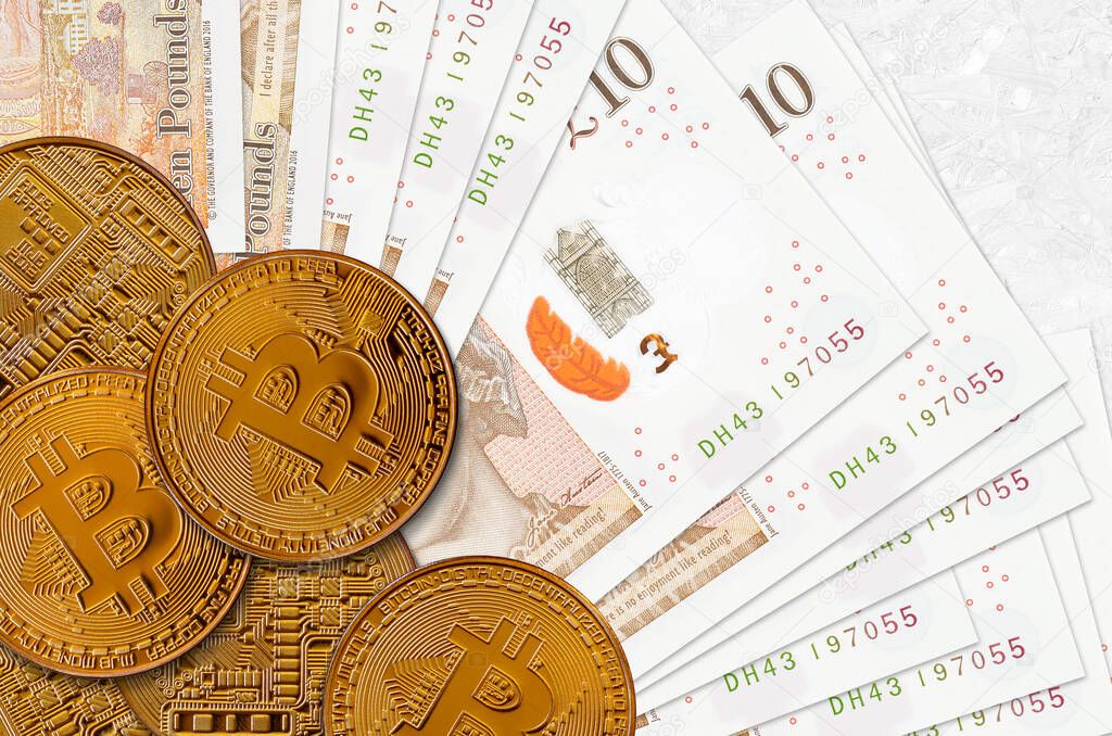 10 British pounds bills and golden bitcoins. Cryptocurrency investment concept. Crypto mining or trading transactions