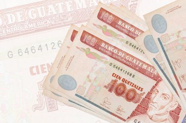 100 Guatemalalı quetzales banknotu büyük yarı şeffaf banknotun arka planında duruyor. Ulusal para biriminin soyut sunumu. İş konsepti