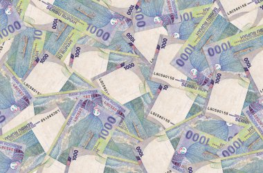 1000 Endonezya rupiası banknotları büyük bir yığın halinde duruyor. Zengin yaşam kavramsal geçmişi. Büyük miktarda para.
