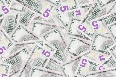 5 dolarlık banknotlar yığının içinde yatıyor. Zengin yaşam kavramsal geçmişi. Büyük miktarda para.