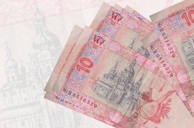 10 Ukrayna hrivniası banknotları büyük yarı şeffaf banknotların arka planında duruyor. Ulusal para biriminin soyut sunumu. İş konsepti
