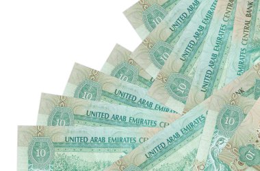 10 BAE Dirhams banknotu beyaza izole edilmiş farklı bir sırayla yatar. Yerel bankacılık ya da para kazanma konsepti. İş arkaplanı afişi