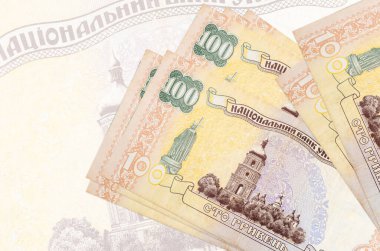 100 Ukrayna hrivniası banknotları büyük yarı şeffaf banknotların arka planında duruyor. Ulusal para biriminin soyut sunumu. İş konsepti