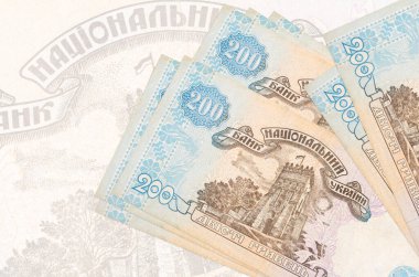 200 Ukrayna hrivniası banknotları büyük yarı şeffaf banknotların arka planında duruyor. Ulusal para biriminin soyut sunumu. İş konsepti