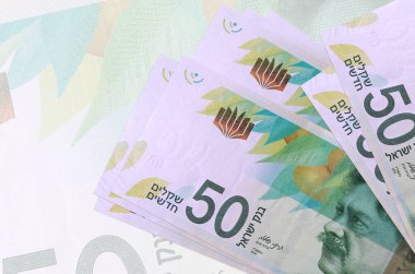 Yarı şeffaf banknotların arka planında 50 yeni İsrail şekeli var. Ulusal para biriminin soyut sunumu. İş konsepti