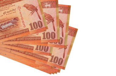 100 Sri Lanka rupisi küçük gruplar halinde ya da beyaz paketler halinde yatar. Kopyalama alanı olan bir model. İş ve para değişimi kavramı