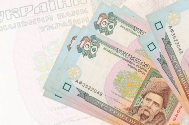 100 Ukrayna hrivniası banknotları büyük yarı şeffaf banknotların arka planında duruyor. Ulusal para biriminin soyut sunumu. İş konsepti