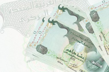 10 BAE dirhem faturası büyük yarı şeffaf banknotun arka planında duruyor. Ulusal para biriminin soyut sunumu. İş konsepti