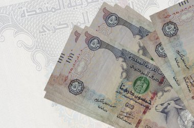 50 BAE dirhem banknotları büyük yarı şeffaf banknotların arka planında duruyor. Ulusal para biriminin soyut sunumu. İş konsepti