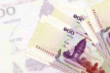 100 Kamboçyalı isyan faturası büyük yarı şeffaf banknotun arka planında duruyor. Ulusal para biriminin soyut sunumu. İş konsepti