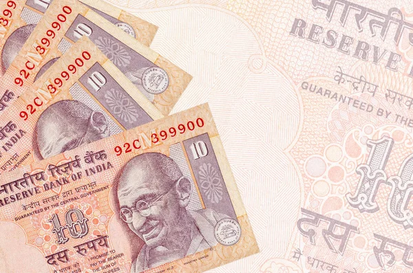 10のインドのルピー札は 大きな半透明の銀行券を背景に積み重なっています コピースペース付き概要事業の背景 — ストック写真