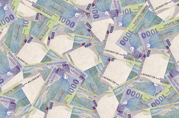1000 Endonezya rupiası banknotları büyük bir yığın halinde duruyor. Zengin yaşam kavramsal geçmişi. Büyük miktarda para.