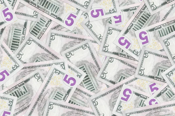 5 dolarlık banknotlar yığının içinde yatıyor. Zengin yaşam kavramsal geçmişi. Büyük miktarda para.