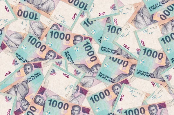 1000 Endonezya rupiası banknotları büyük bir yığın halinde duruyor. Zengin yaşam kavramsal geçmişi. Büyük miktarda para.
