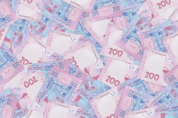 200 Ukrayna hrivniası banknotları büyük yığının içinde yatıyor. Zengin yaşam kavramsal geçmişi. Büyük miktarda para.