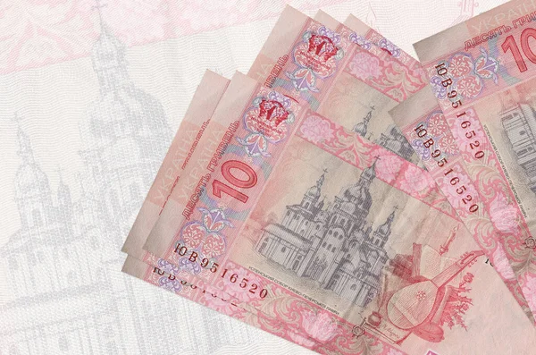 10 Ukrayna hrivniası banknotları büyük yarı şeffaf banknotların arka planında duruyor. Ulusal para biriminin soyut sunumu. İş konsepti