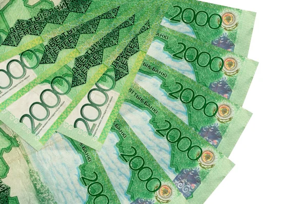2000 Kazakistanlı tenge banknotları beyaz arka planda izole edilmiş ve fotokopi alanı fan şeklinde üst üste yığılmış. Finansal işlemler kavramı