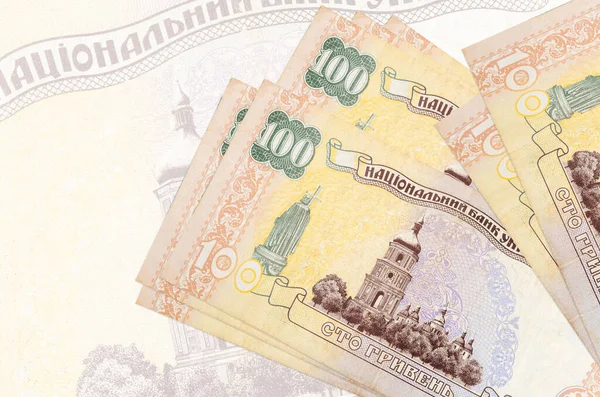 100 Ukrayna hrivniası banknotları büyük yarı şeffaf banknotların arka planında duruyor. Ulusal para biriminin soyut sunumu. İş konsepti