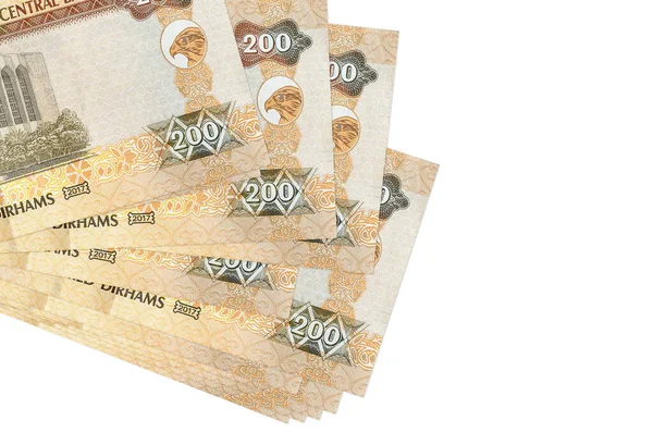 200 BAE dirhem banknotları küçük gruplar halinde ya da beyaza izole edilmiş paketler halinde yatar. Kopyalama alanı olan bir model. İş ve para değişimi kavramı